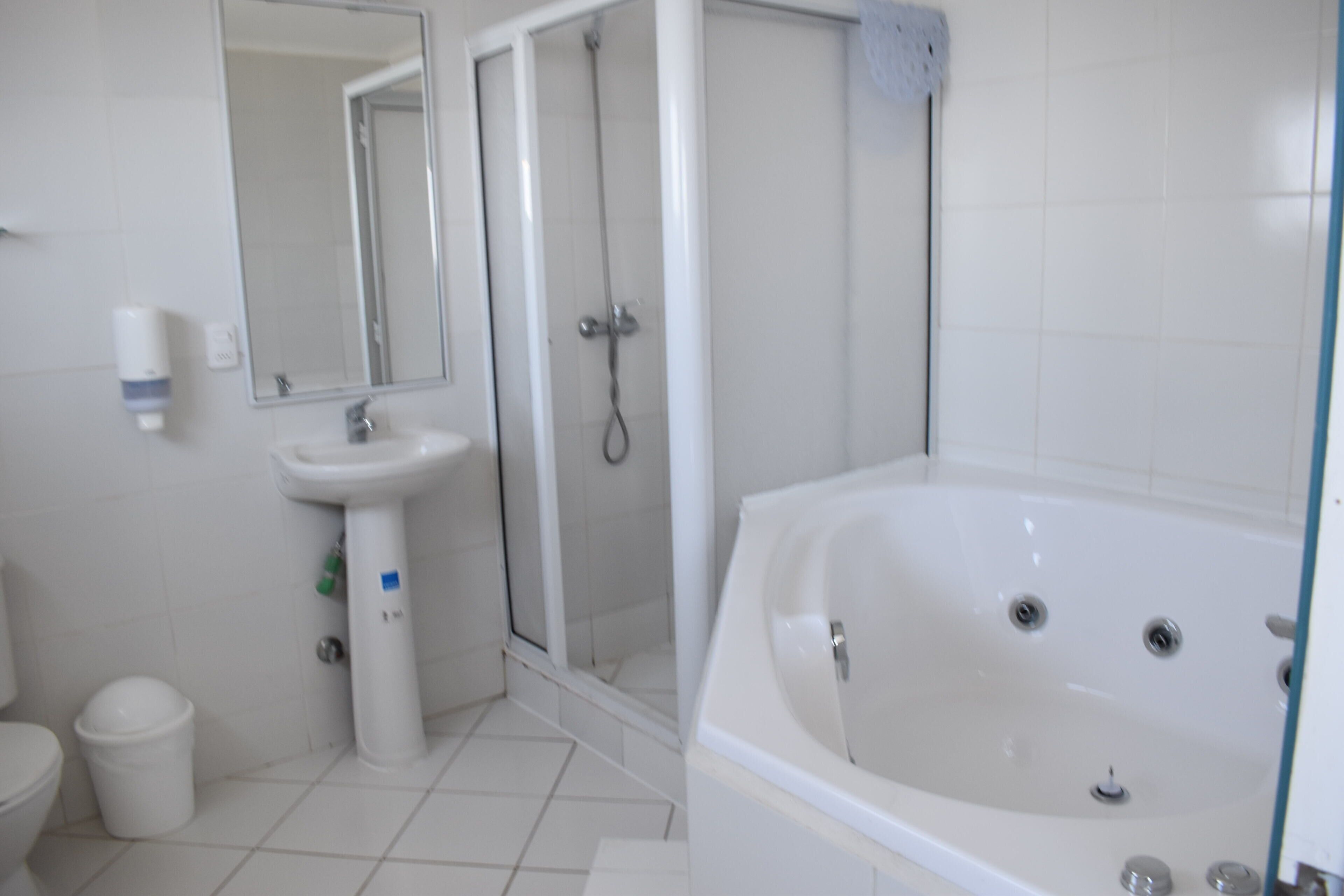 Habitación matrimonial con bañera de hidromasaje y vista al mar