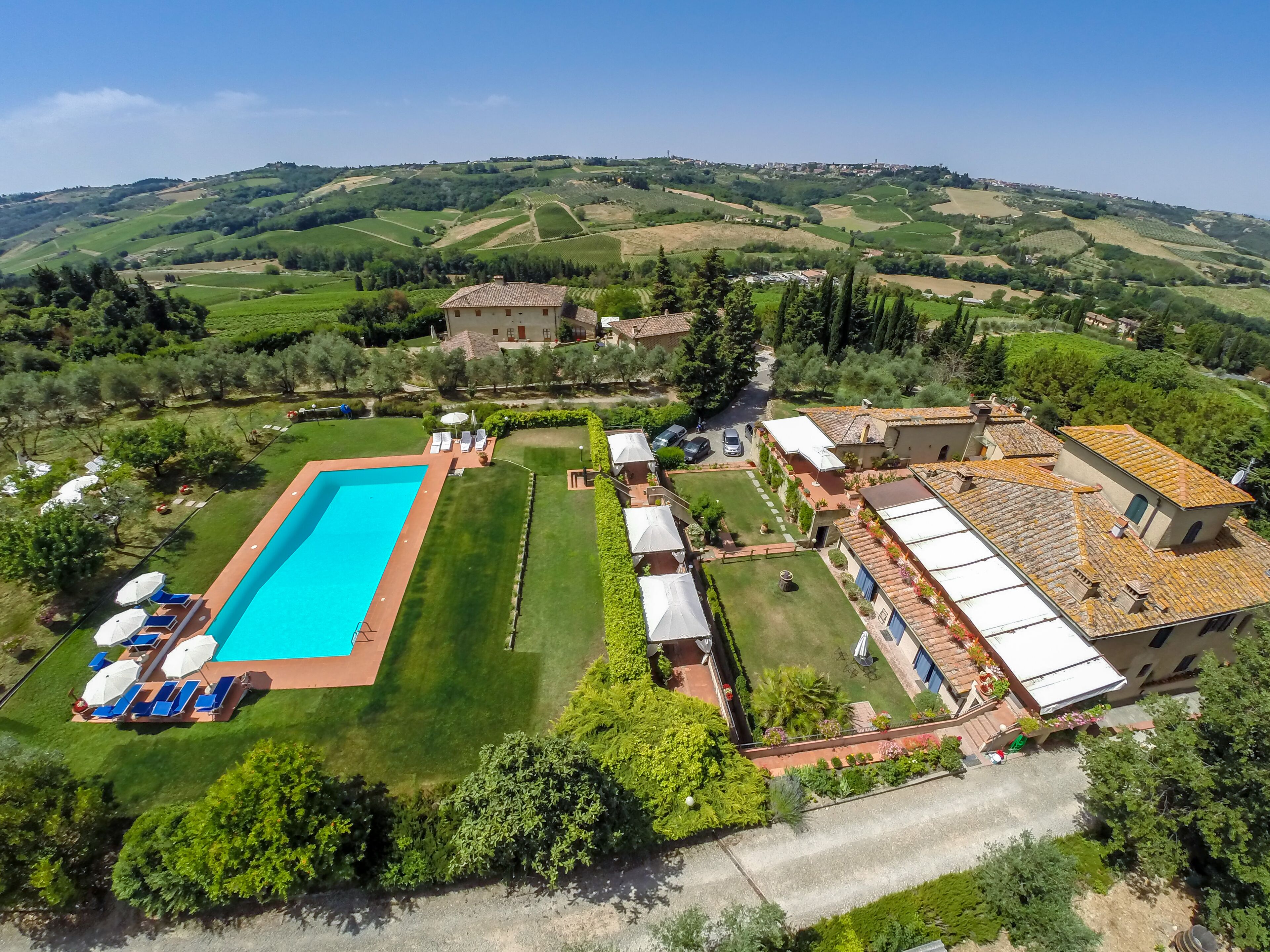 Apartment in the Chianti countryside with swimming pool, lawn, table and deck chairs 